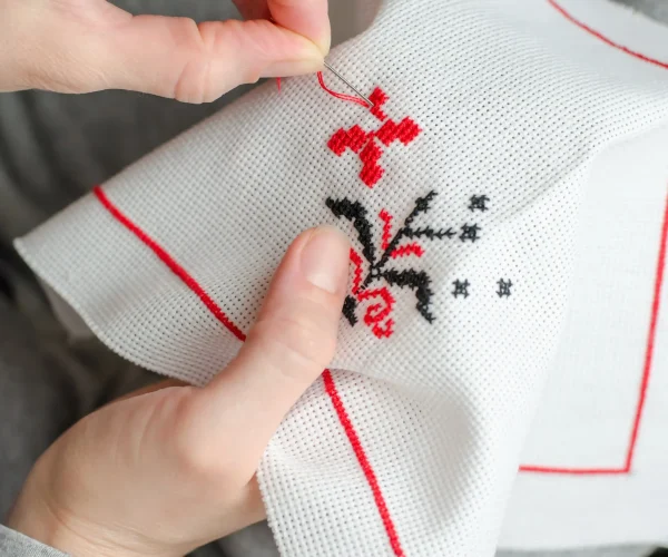 close-up-of-a-woman-s-hands-cross-stitching-on-a-w-2026-01-06-09-53-50-utc
