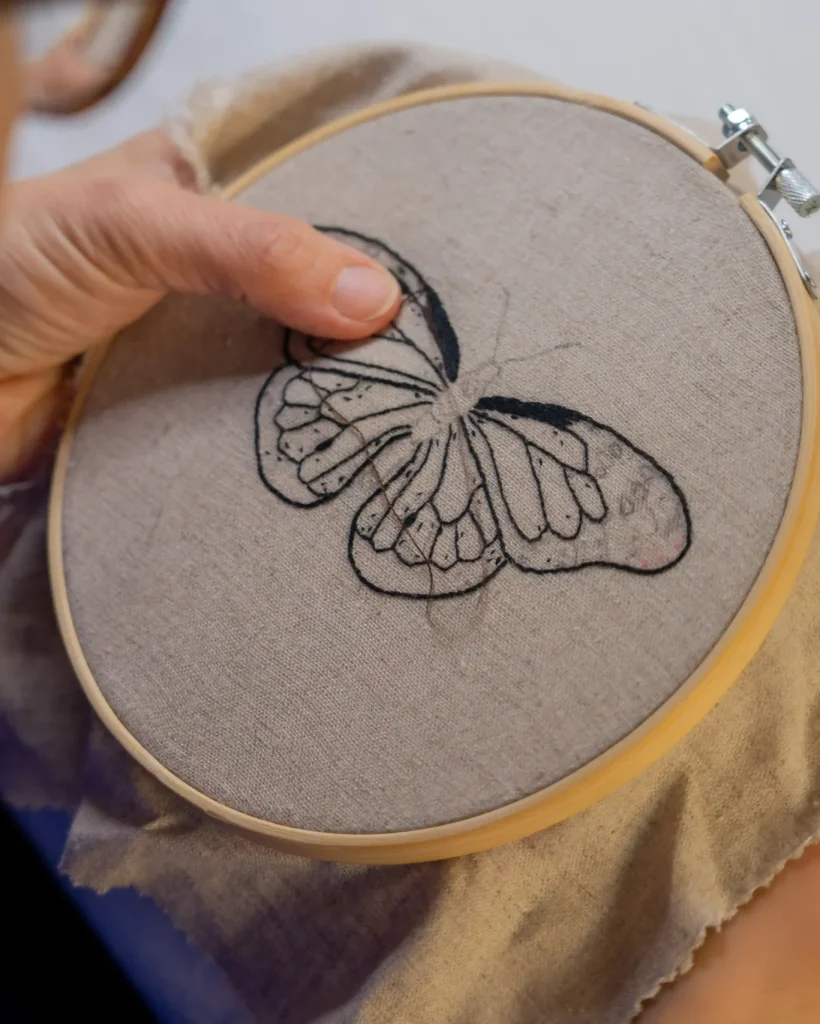 woman-embroidering-a-butterfly-by-hand-2026-01-07-01-44-03-utc