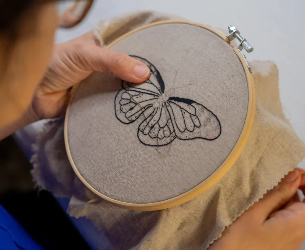 woman-embroidering-a-butterfly-by-hand-2026-01-07-01-44-03-utc